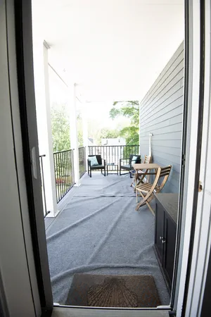 Sunny deck with cozy seating and pleasant outdoor views.